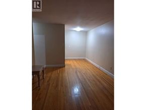 Vancouver apartment for rent - A room with wooden floors and a chair.