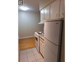 Vancouver apartment for rent - A white refrigerator sits in a kitchen next to a stove.