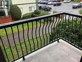 Richmond apartment for rent - A balcony with a black railing overlooks a parking lot.