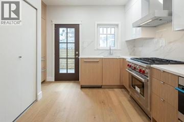Vancouver townhouse for rent - A kitchen with wooden floors and a stainless steel stove top oven.