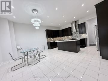 Brampton (Credit Valley) apartment for rent - A modern kitchen with a glass table and black cabinets.