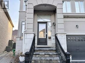 Brampton (Credit Valley) apartment for rent - A house with a black front door and a small garden in front.