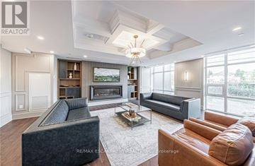 Hamilton (Waterdown) condo for rent - A living room with a grey couch, a brown leather couch, a coffee table and a fireplace.