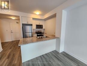 Hamilton (Waterdown) condo for rent - A kitchen with a stainless steel refrigerator, microwave, and oven.