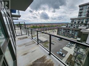 Hamilton (Waterdown) condo for rent - A balcony with a view of a parking lot and buildings.