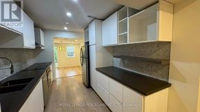 Toronto (Wexford-Maryvale) apartment for rent - A modern kitchen with white cabinets and black countertops.