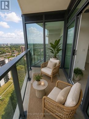 Toronto (Humber Heights) condo for rent - A balcony with a chair and a table with a plant on it.