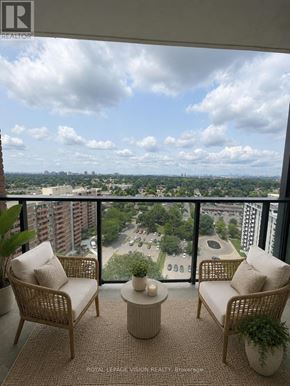 Toronto (Humber Heights) condo for rent - A balcony with two chairs and a table overlooking a cityscape.