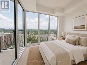 Toronto (Humber Heights) condo for rent - A bedroom with a large bed and a view of the city.