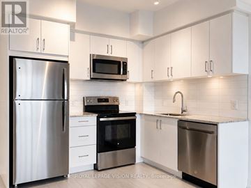 Toronto (Humber Heights) condo for rent - A kitchen with white cabinets and stainless steel appliances.