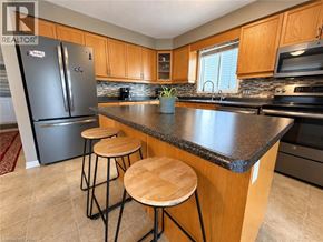 Waterloo apartment for rent - A kitchen with a black fridge and wooden stools.