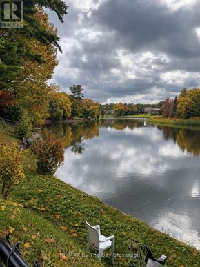 Wasaga Beach apartment for rent - A serene lake surrounded by autumn trees and a cloudy sky.