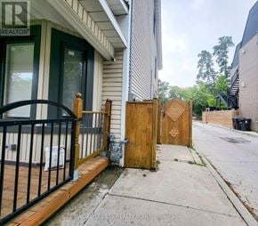 Toronto (Junction Area) multi-family for rent - A wooden gate with a carved design is in front of a house.