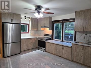 East Garafraxa apartment for rent - A kitchen with wooden cabinets and a stainless steel refrigerator.