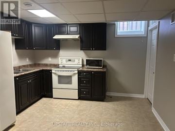 Vaughan (Sonoma Heights) apartment for rent - A kitchen with black cabinets and a white stove top oven.