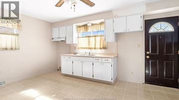 Windsor apartment for rent - A kitchen with white cabinets and a black door.