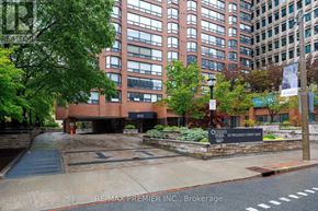 Toronto (Bay Street Corridor) condo for rent - A street view of a building with a sign that reads "Queens Wharf Street Inn".