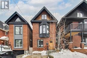 Toronto (South Riverdale) apartment for rent - A house with a brown brick exterior and a black roof.