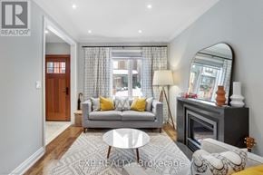 Toronto (South Riverdale) apartment for rent - A living room with a grey couch, a fireplace, and a large mirror.