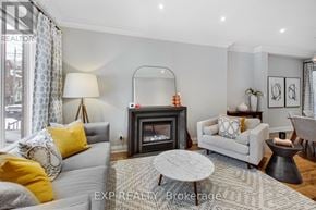 Toronto (South Riverdale) apartment for rent - A living room with a grey couch, a grey armchair, a grey coffee table, a grey fireplace, a grey rug, a grey floor, a grey wall, a grey ceiling, a grey floor lamp, a grey floor