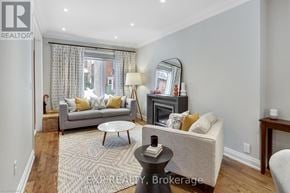 Toronto (South Riverdale) apartment for rent - A living room with a grey couch, a fireplace, and a mirror on the wall.