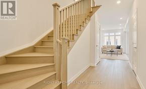 Barrie (Painswick South) apartment for rent - A wooden staircase leads to a bright living room.