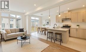 Barrie (Painswick South) apartment for rent - A modern kitchen with a breakfast bar and a living room area.