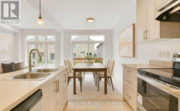Barrie (Painswick South) apartment for rent - A modern kitchen with a dining table and chairs in the middle.