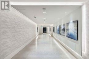 Toronto (Islington-City Centre West) condo for rent - A long hallway with pictures on the wall and a light on the ceiling.