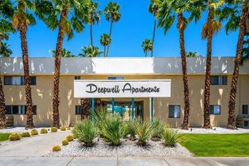 Palm Springs apartment for rent - Deepwell Apartments building with palm trees in front.