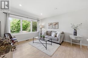 Haldimand apartment for rent - A living room with a grey couch, a glass coffee table, and a white side table.