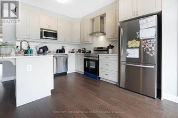Ottawa townhouse for rent - A kitchen with a refrigerator covered in magnets and papers.
