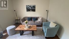 Brantford townhouse for rent - A living room with a grey couch, a blue armchair, and a wooden coffee table.