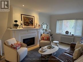 Toronto (Lawrence Park South) fourplex for rent - A living room with a fireplace and a painting above it.