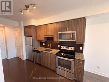 Richmond Hill (Langstaff) condo for rent - A modern kitchen with wooden cabinets and stainless steel appliances.