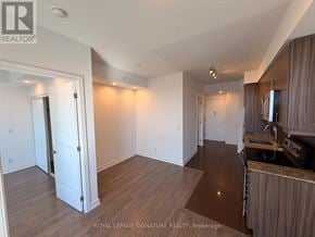 Richmond Hill (Langstaff) condo for rent - A well-lit, spacious room with wooden flooring and white walls.