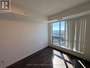 Richmond Hill (Langstaff) condo for rent - A room with a large window overlooking a cityscape.