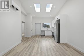 St. Catharines (E. Chester) apartment for rent - A spacious, empty room with a kitchen area in the background.