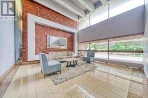 Toronto (Don Valley Village) condo for rent - A living room with a brick wall and a grey sofa.