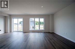 Kitchener apartment for rent - A spacious room with wood flooring and large windows.
