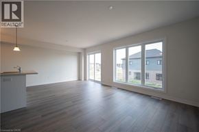 Kitchener apartment for rent - A spacious room with wooden flooring and large windows.