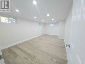 Brantford apartment for rent - A spacious room with wooden flooring and white walls.