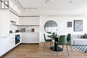 Toronto (Thorncliffe Park) condo for rent - A modern kitchen with white cabinets and a dining table with four chairs.