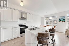 Pickering townhouse for rent - A modern kitchen with white cabinets and a large island.