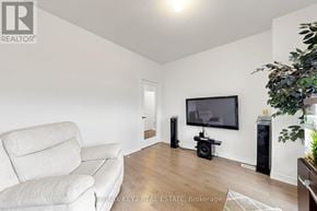 Pickering townhouse for rent - A living room with a couch, television, and a plant.