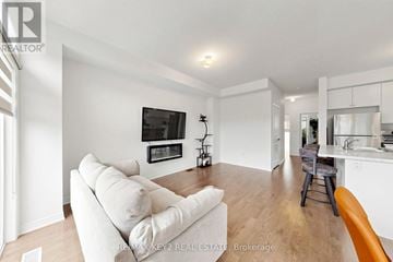 Pickering townhouse for rent - A living room with a white couch and a television on the wall.