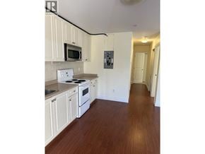 North Blackburn apartment for rent - A kitchen with white cabinets and a microwave above the stove.