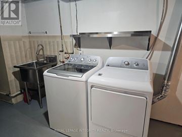 Ottawa apartment for rent - A pair of white front loading washing machines in a laundry room.