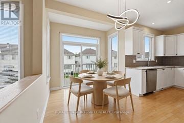 Ottawa apartment for rent - A dining area with a table set for two and a kitchen in the background.