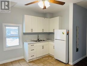 St. Catharines (Oakdale) duplex for rent - A kitchen with white cabinets and a white refrigerator.